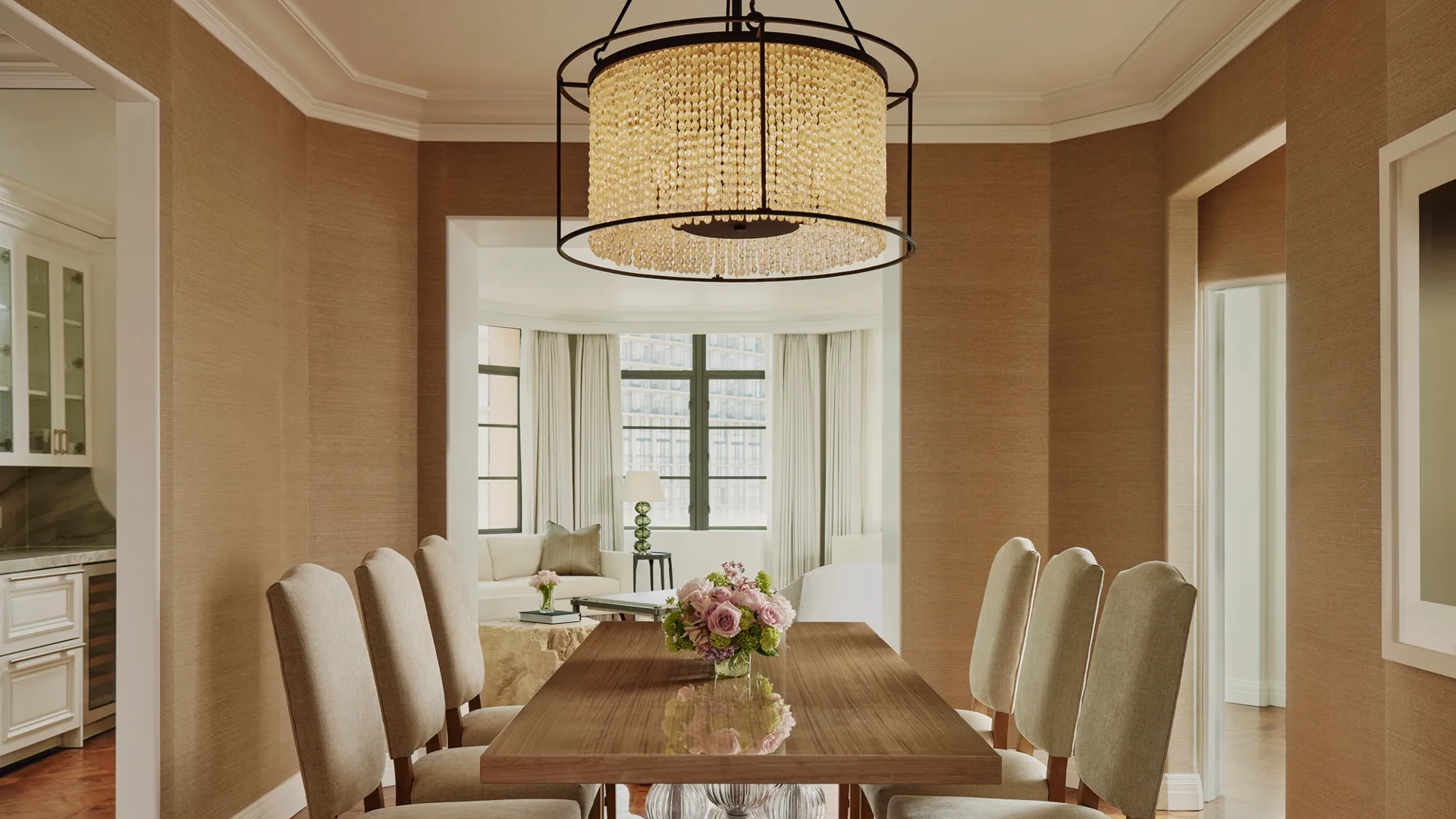 Dining area in the Beverly Three-Bedroom Residence, featuring a large round table, contemporary chairs, and soft lighting.