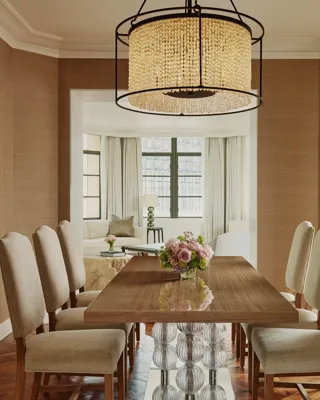 Dining area in the Beverly Three-Bedroom Residence, featuring a large round table, contemporary chairs, and soft lighting.