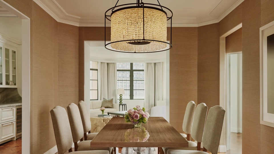 Dining area in the Beverly Three-Bedroom Residence, featuring a large round table, contemporary chairs, and soft lighting.