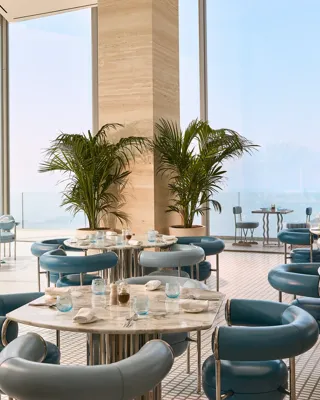 Une scène de restauration raffinée au Riviera Restaurant du Maybourne Riviera, avec un design contemporain élégant et des vues sur la Méditerranée.