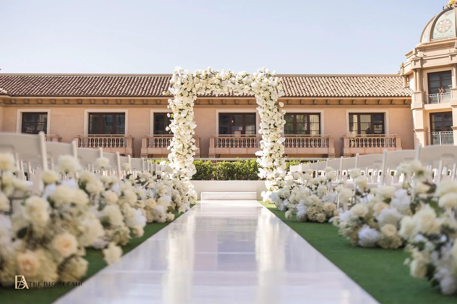 Beverly Hills garden terrace wedding aisle lined with white flowers and tall candles.