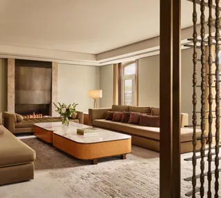 Spacious Opus Suite living room with sofas, marble tables, and a modern fireplace