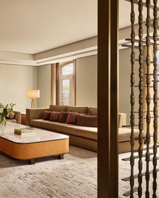 Spacious Opus Suite living room with sofas, marble tables, and a modern fireplace