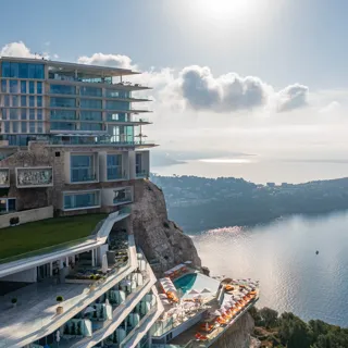Clifftop hotel with terraced levels, a pool deck, and panoramic views over the sea and coastline.