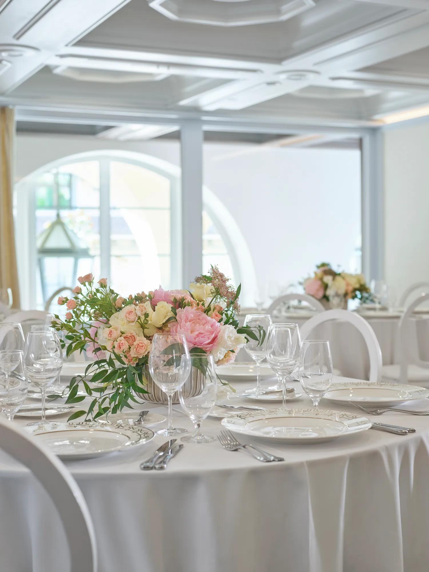 Beverly conference room round tables with blush floral centerpieces and crystal glassware.