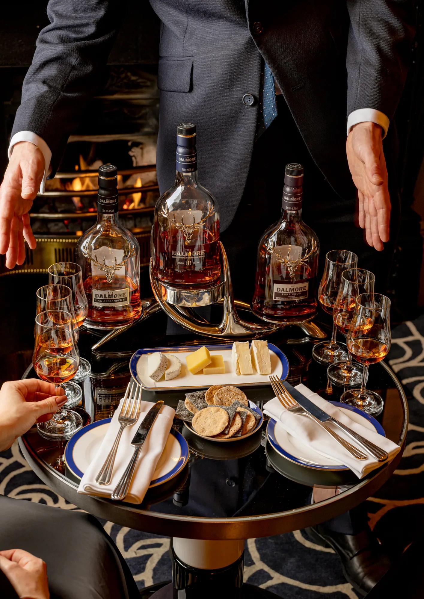 A couple of whisky bottles standing side by side, their labels and amber liquid clearly visible.