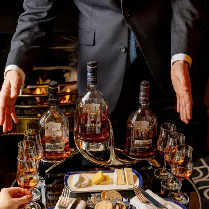 A couple of whisky bottles standing side by side, their labels and amber liquid clearly visible.
