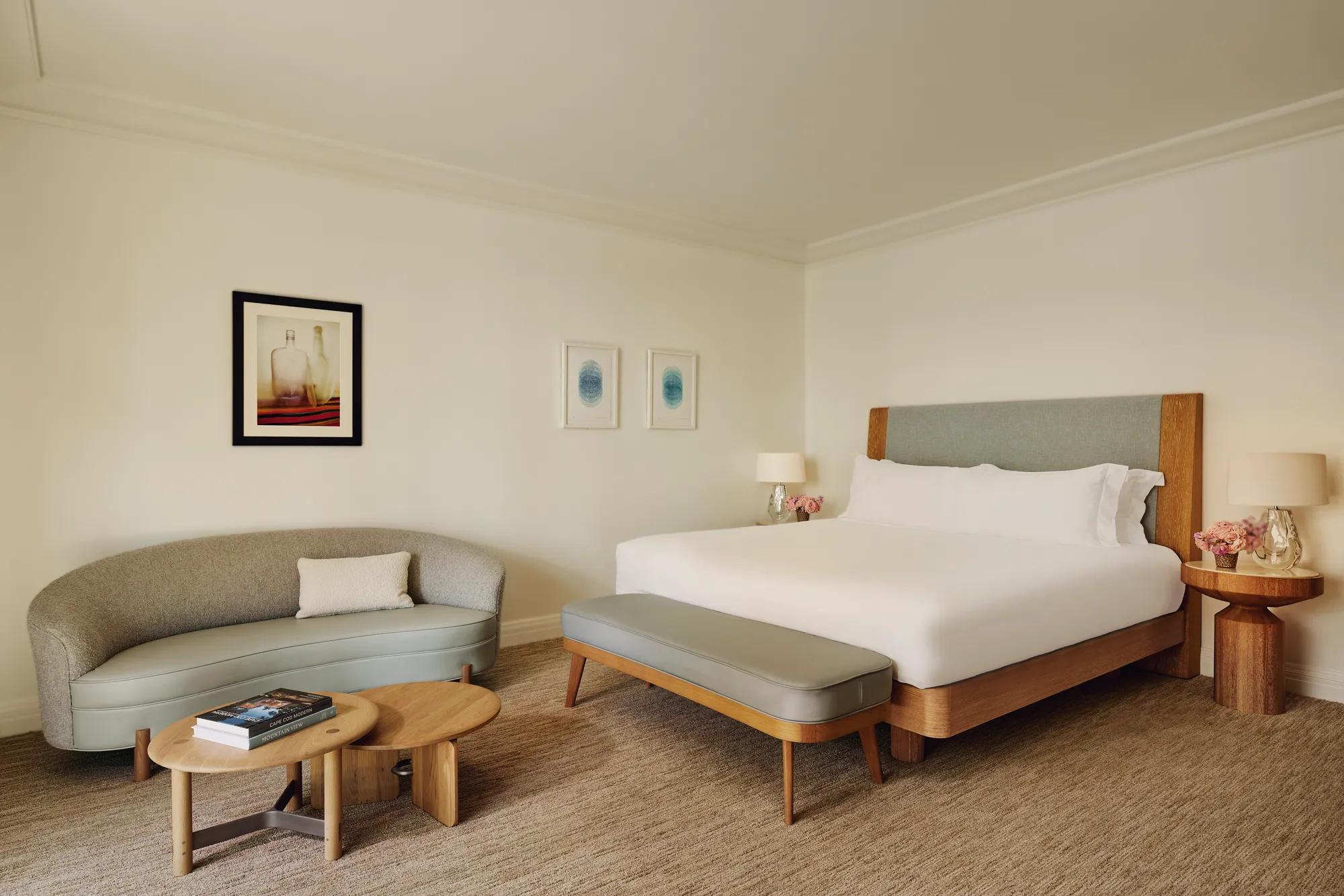 Two-Bedroom Library Suite bedroom with king bed, upholstered headboard, and warm-toned décor in an elegant, residential-style setting.