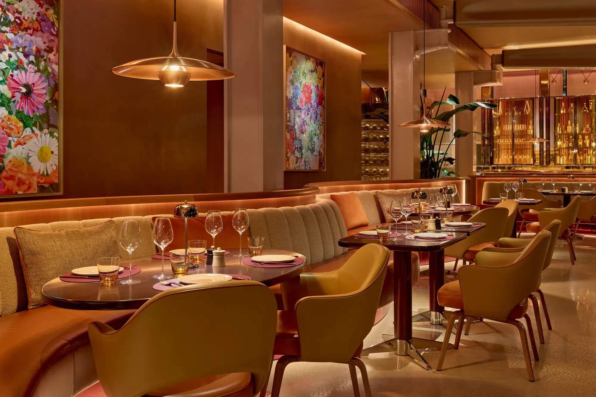 A restaurant sitting area with tables, chairs, and soft ambient lighting