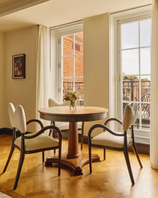 A Corner Terrace Suite at Claridge’s featuring elegant contemporary décor, soft natural light, and access to a private terrace with views over Mayfair.