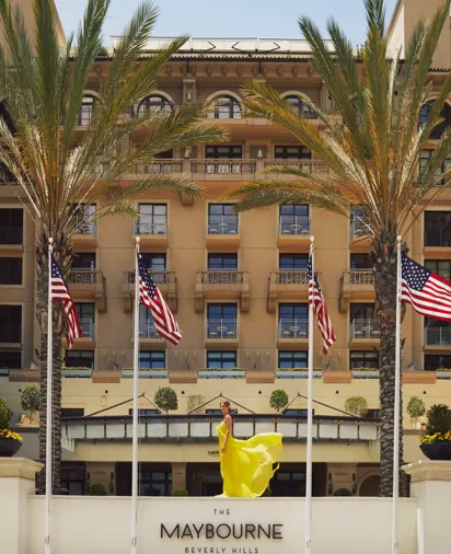 The front entrance of The Maybourne Beverly Hills with its elegant façade and palm‑lined walkway.