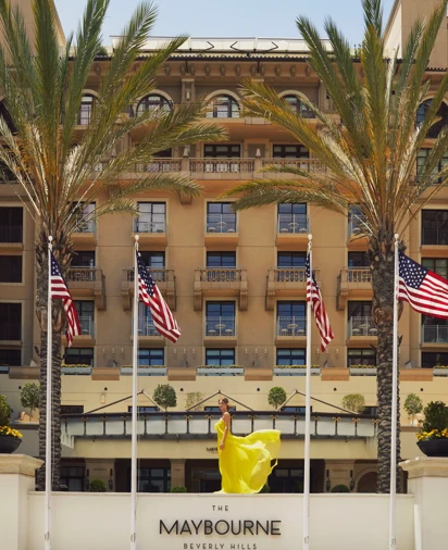 The front entrance of The Maybourne Beverly Hills with its elegant façade and palm‑lined walkway.