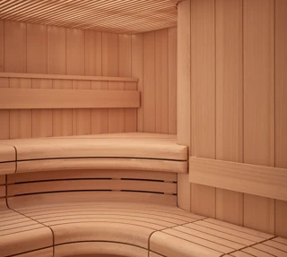 Curved wooden sauna interior with tiered bench seating and slatted walls and ceiling.