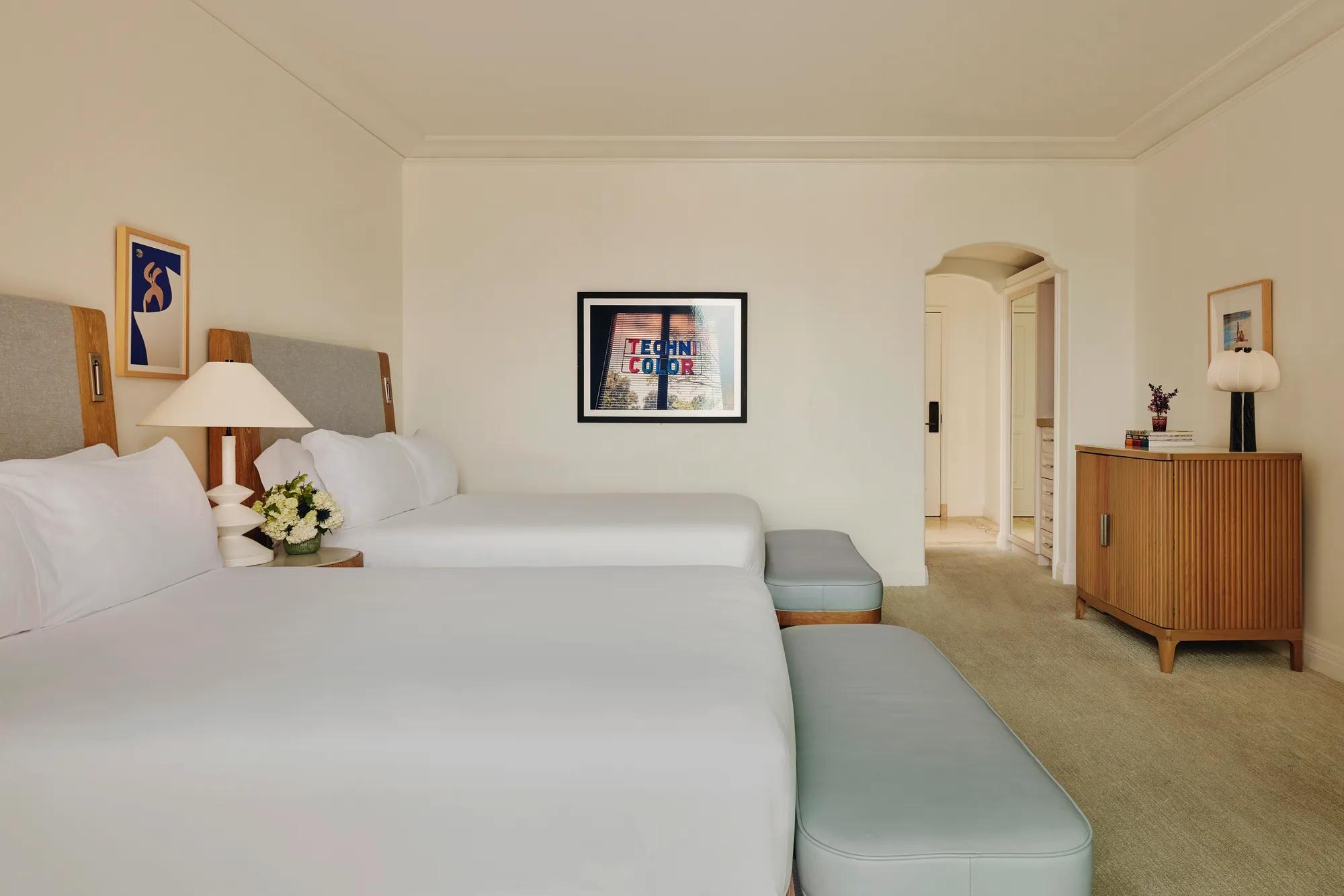 Two-queen bedroom with balcony access, featuring contemporary décor and seating area.