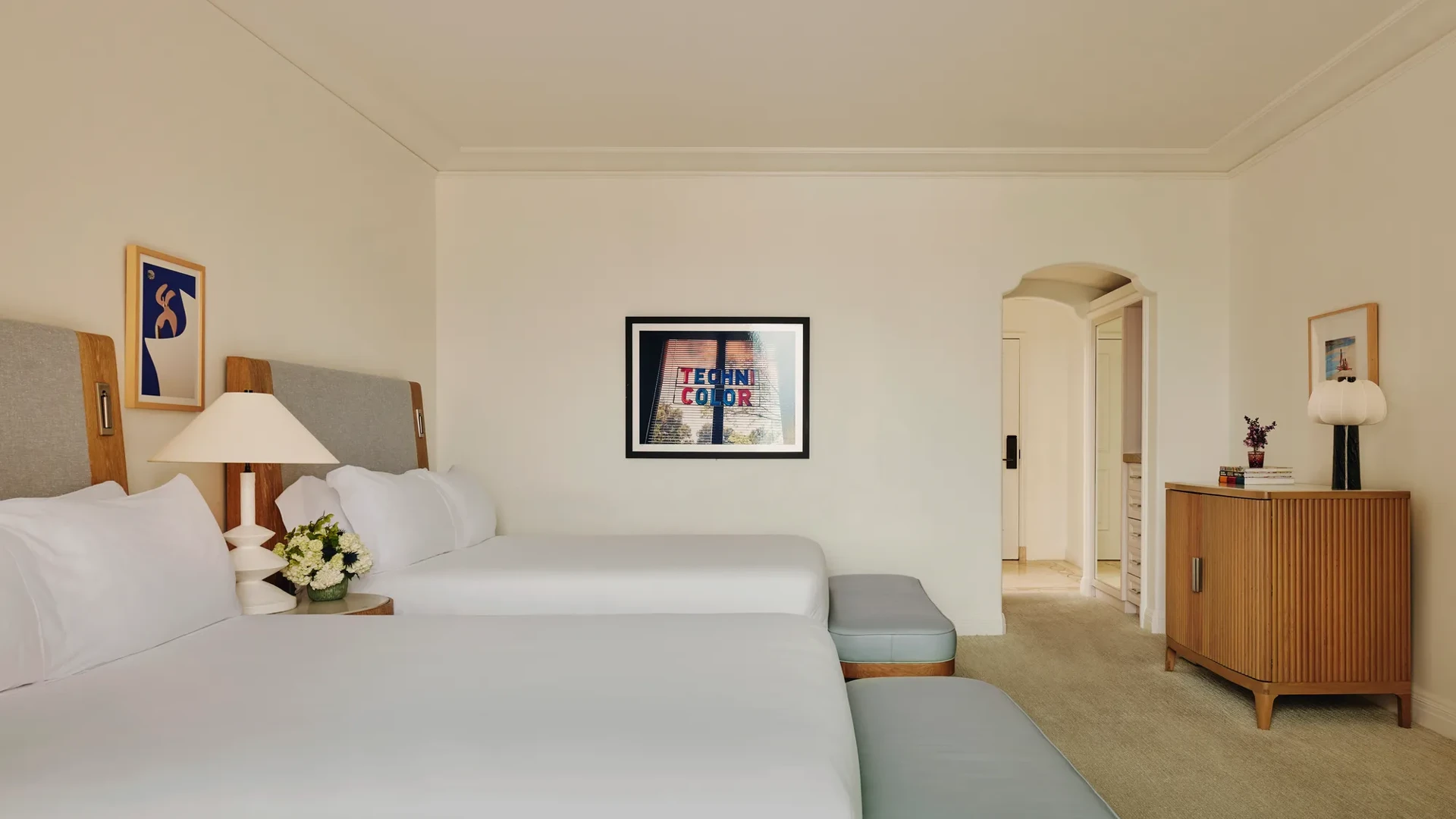 Two-queen bedroom with balcony access, featuring contemporary décor and seating area.
