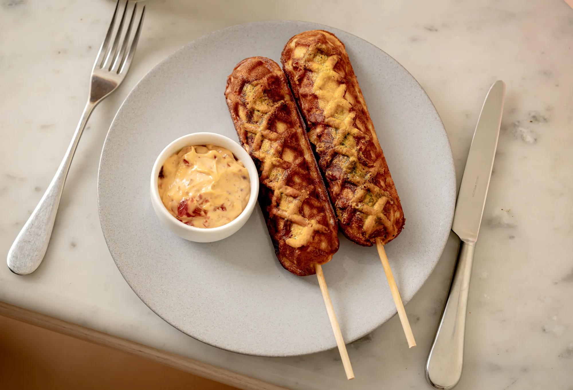 Corn dogs from Art Café by Thibault Hauchard served with a rich dipping sauce.