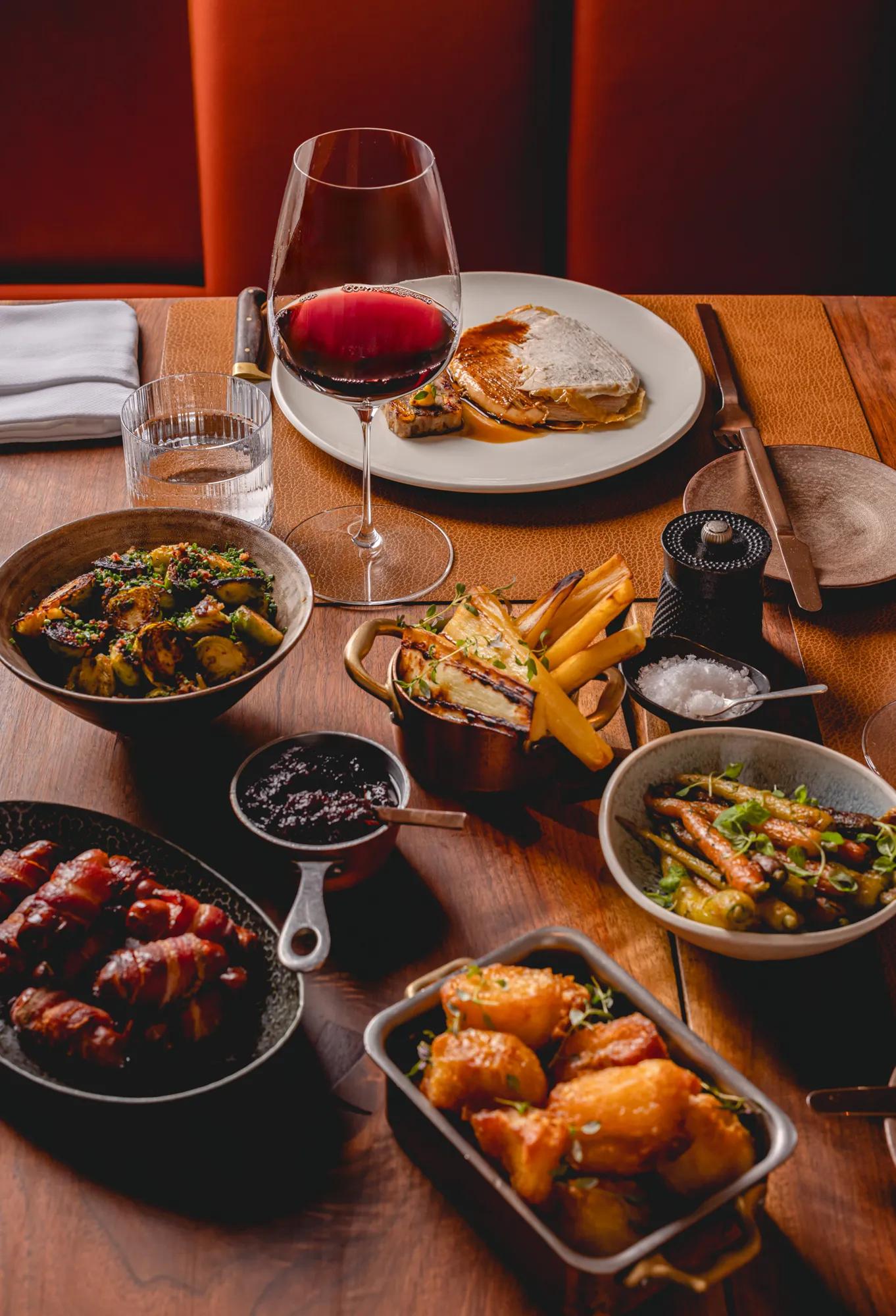 Festive dining dishes served on a restaurant table with a glass of red wine.
