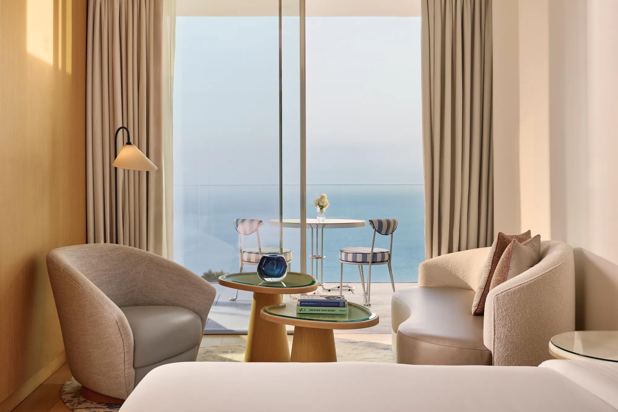 A Sea View Studio at Maybourne Riviera, featuring elegant contemporary décor and large windows framing an open view of the Mediterranean.