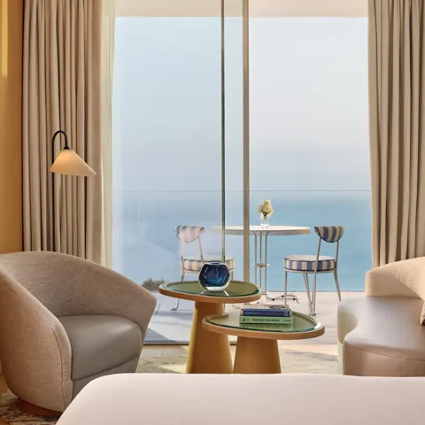 A Sea View Studio at Maybourne Riviera, featuring elegant contemporary décor and large windows framing an open view of the Mediterranean.