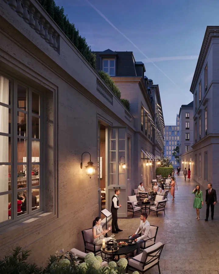 Evening courtyard with outdoor dining, guests seated at tables, warm lighting, and elegant stone buildings lining a narrow walkway.