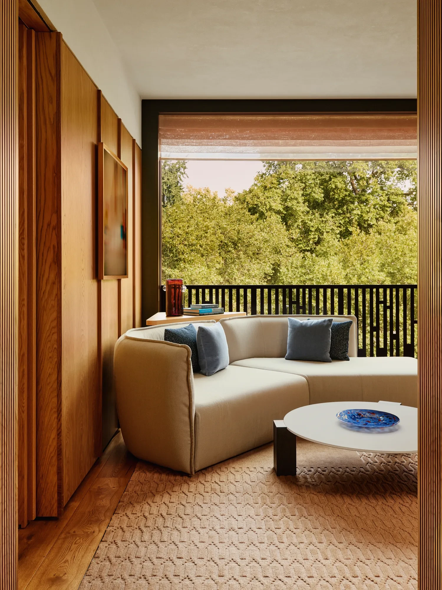 A modern hotel room living area with a beige sofa, coffee table, and soft ambient lighting.