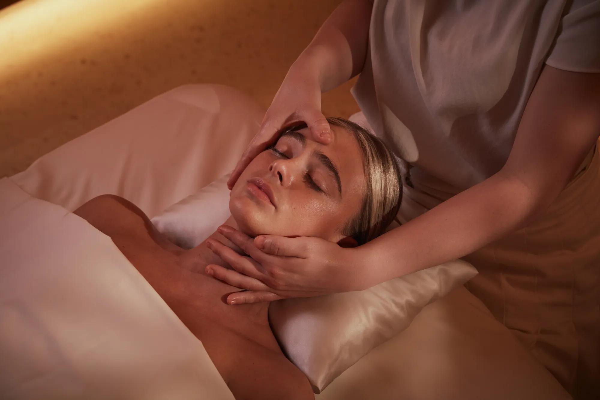 Women having a massage treatment on her face by a therapist.