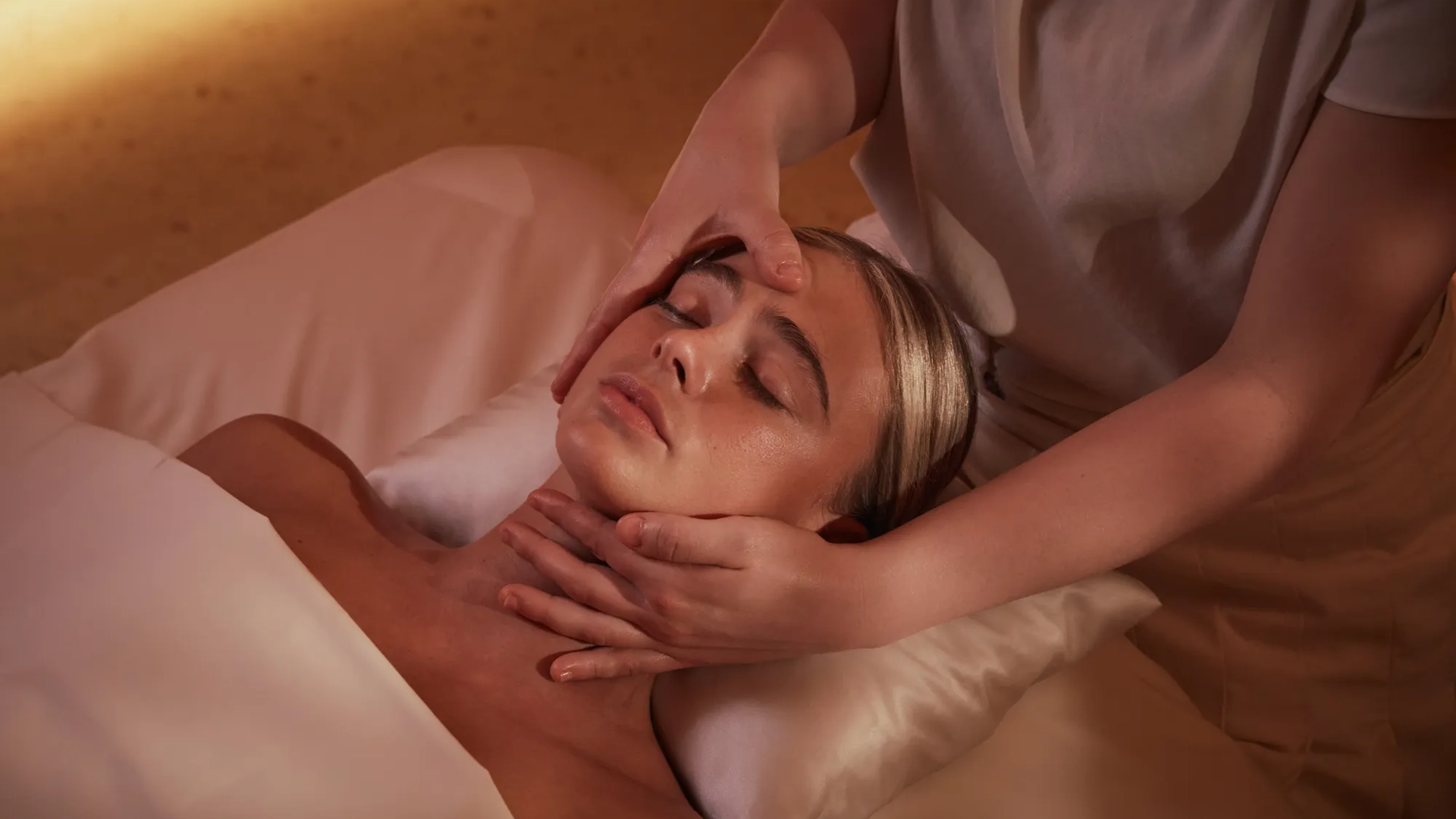 Women having a massage treatment on her face by a therapist.