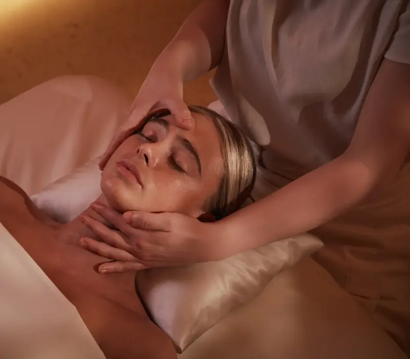 Women having a massage treatment on her face by a therapist.