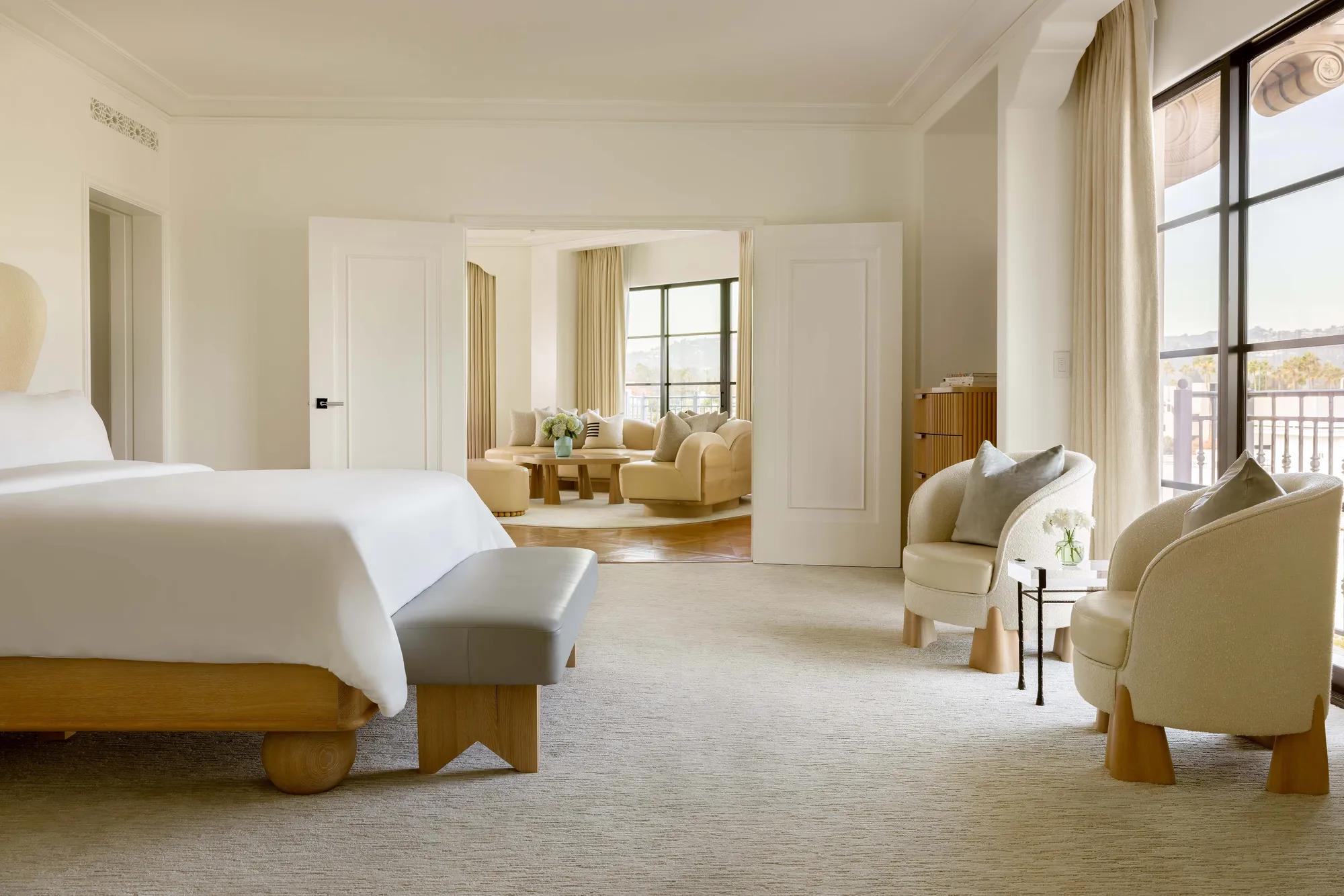 Side view of the Hollywood Suite looking into the living room area with cushioned conversation chairs and natural light from large windows.