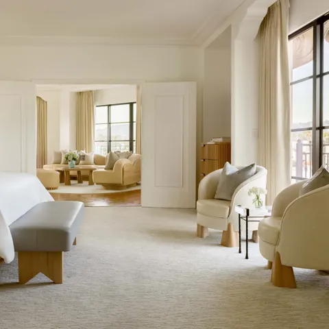 Side view of the Hollywood Suite looking into the living room area with cushioned conversation chairs and natural light from large windows.