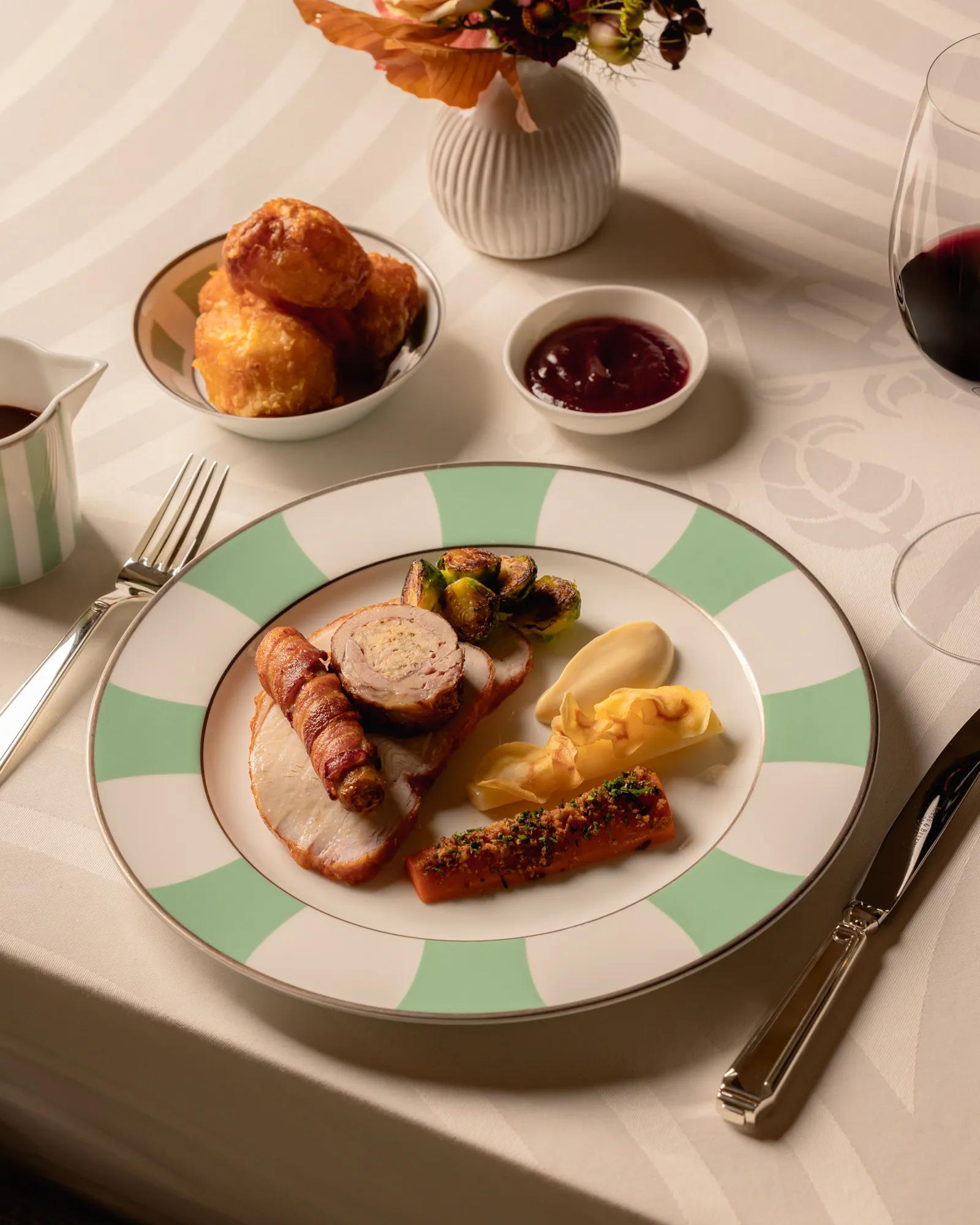 Roast turkey with seasonal vegetables and festive sides served on an elegantly set dining table.