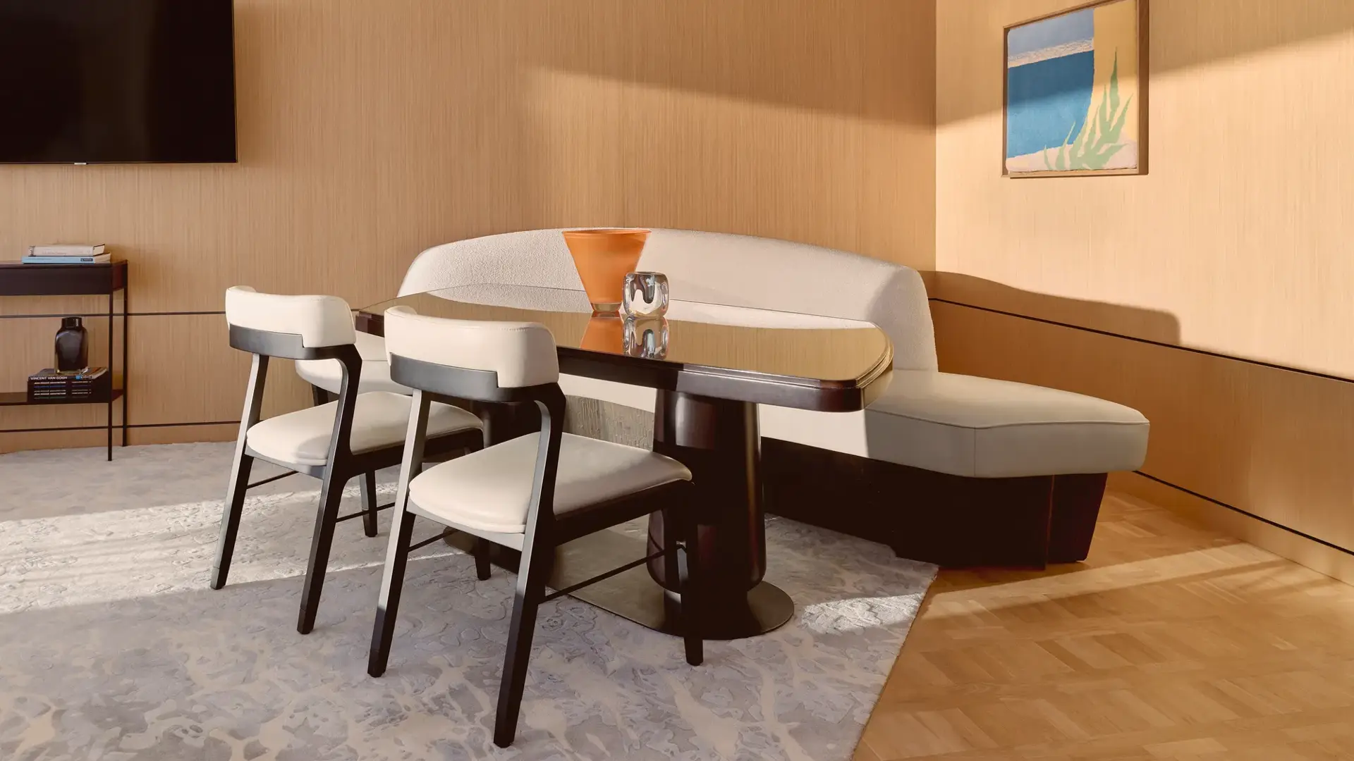 Coin repas élégant avec banquette courbée, chaises modernes et table en bois raffinée, décoré de vases sculpturaux.