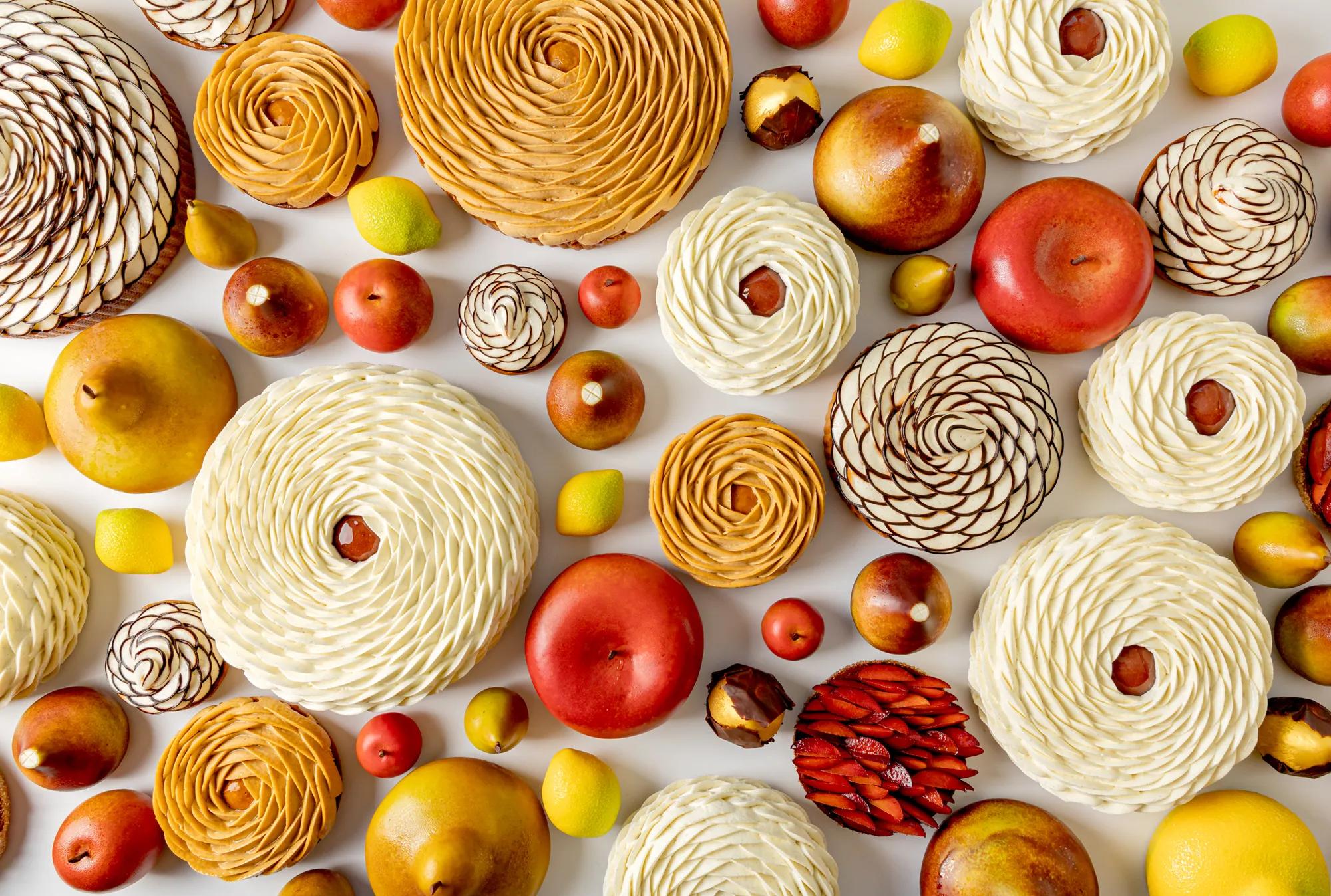 Decorative fruit arrangements and whole fruits displayed in an artistic pattern on a light background.