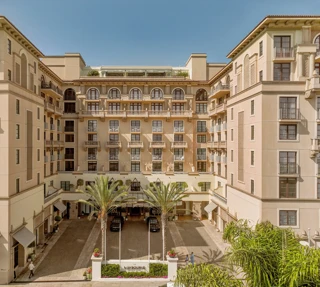 Symmetrical daytime view of The Maybourne Beverly Hills entrance courtyard from above.