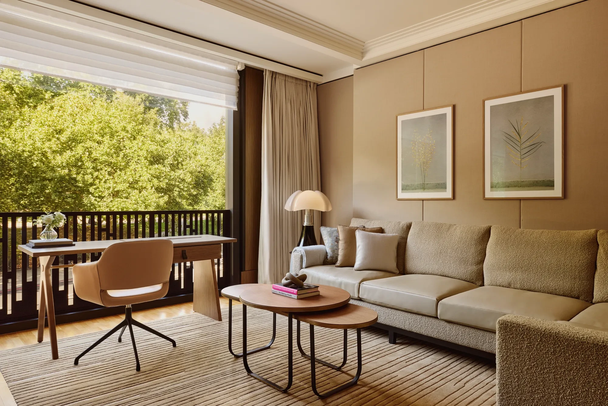 A modern hotel room living area with a sofa, coffee table, and soft ambient lighting.