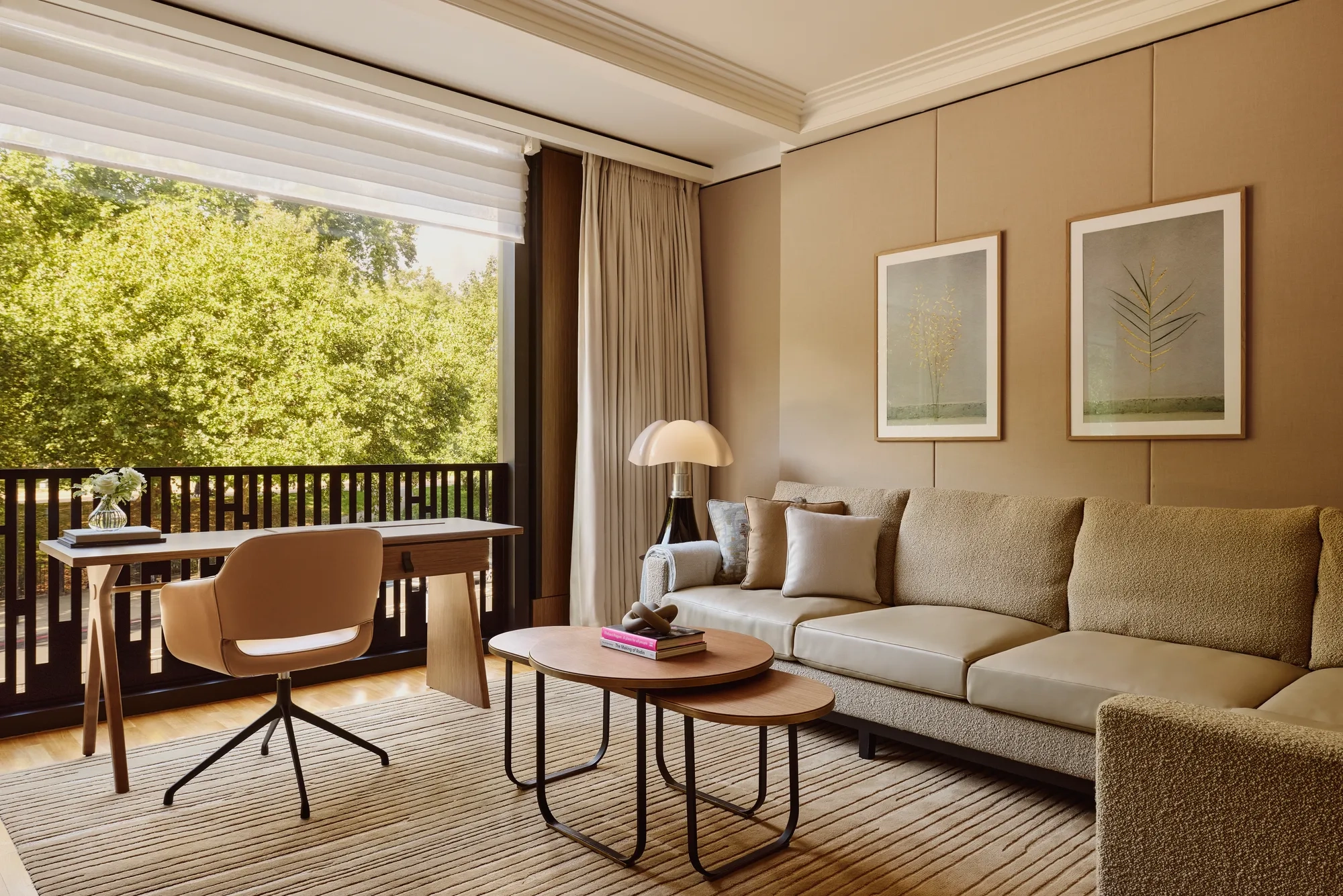 A modern hotel room living area with a sofa, coffee table, and soft ambient lighting.