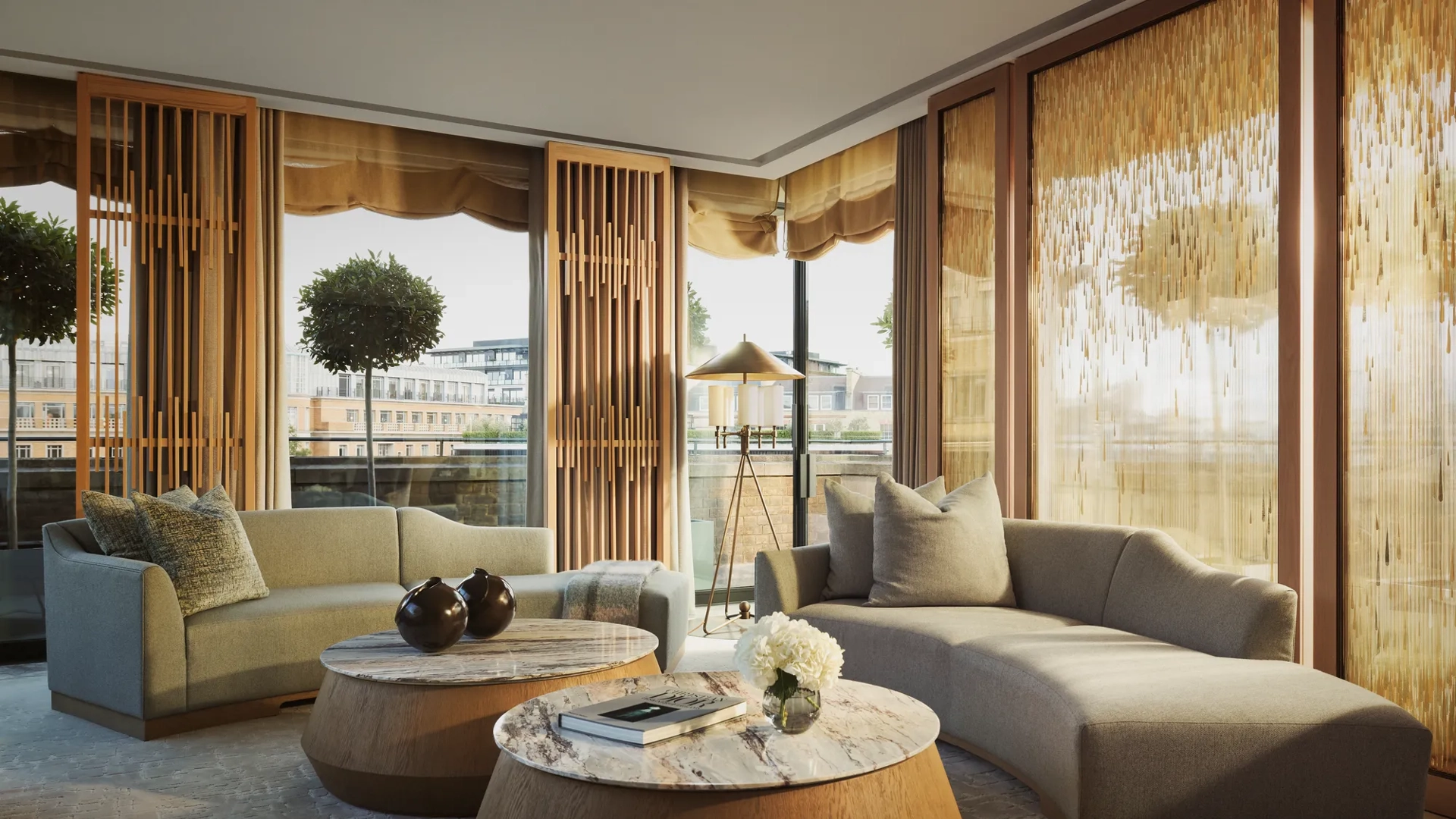 Penthouse living room with curved sofas, round marble tables, and floor-to-ceiling windows with golden drapes