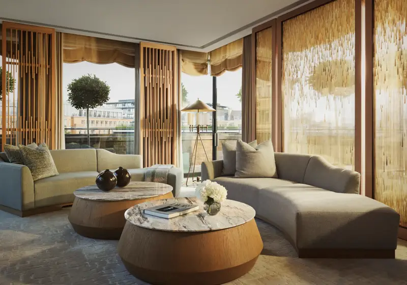 Penthouse living room with curved sofas, round marble tables, and floor-to-ceiling windows with golden drapes