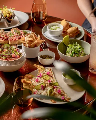 Table filled with tacos, quesadillas, ceviche, salads, cocktails and shared plates at abc kitchens restaurant.