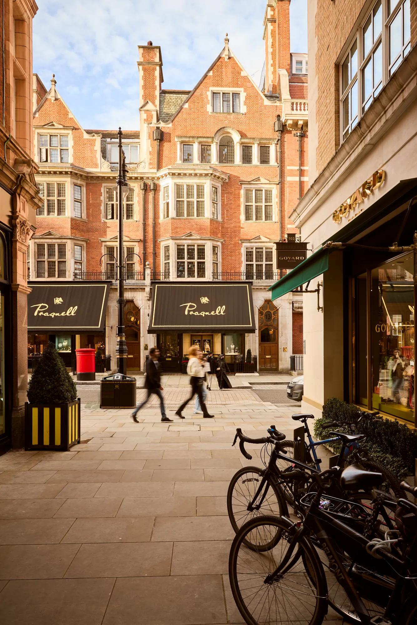 Pedestrian-lined Burlington Gardens with luxury boutiques, bicycles and elegant historic architecture in the heart of Mayfair.