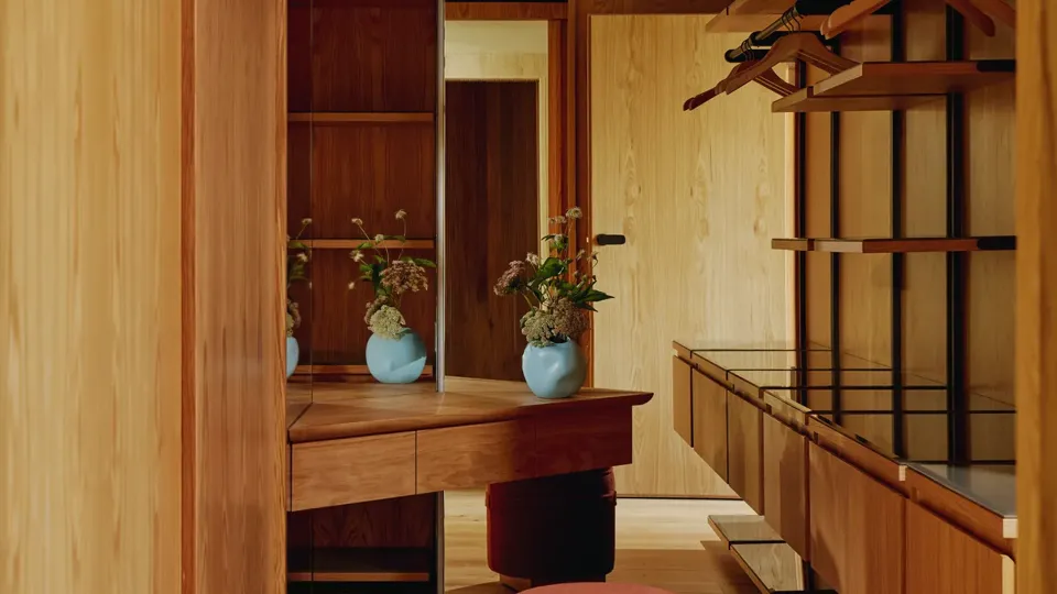 Dressing room with wooden wardrobes and a large mirrored wall