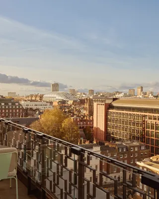 Rooftop terrace at Claridge’s with café tables overlooking the London skyline at sunset
