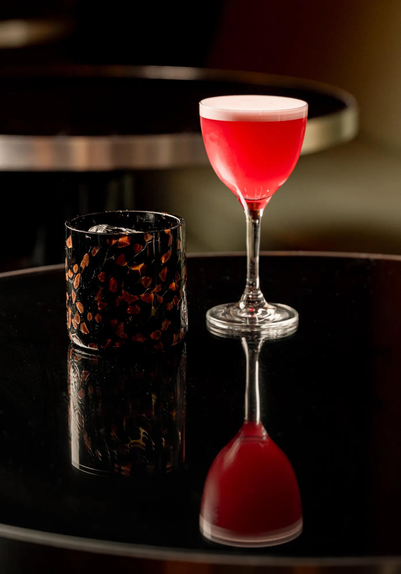 A spring cocktail served at the Coburg Bar, presented with elegant seasonal garnishes and refined glassware in a warm, sophisticated setting.
