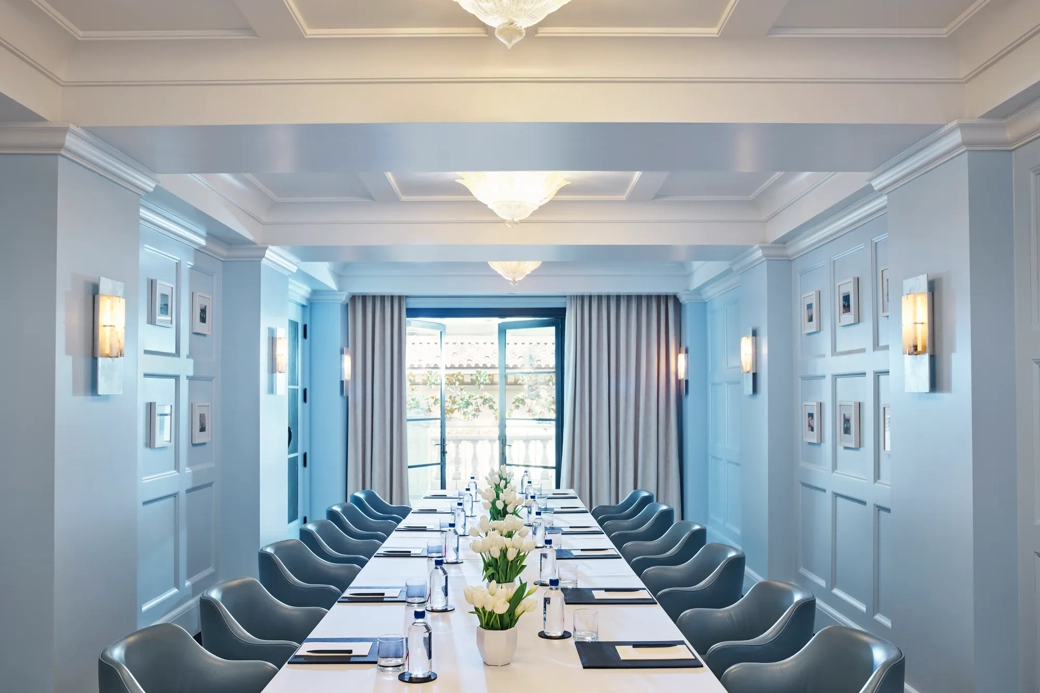 Canon Room boardroom setup with long table, blue paneling, and chandeliers.