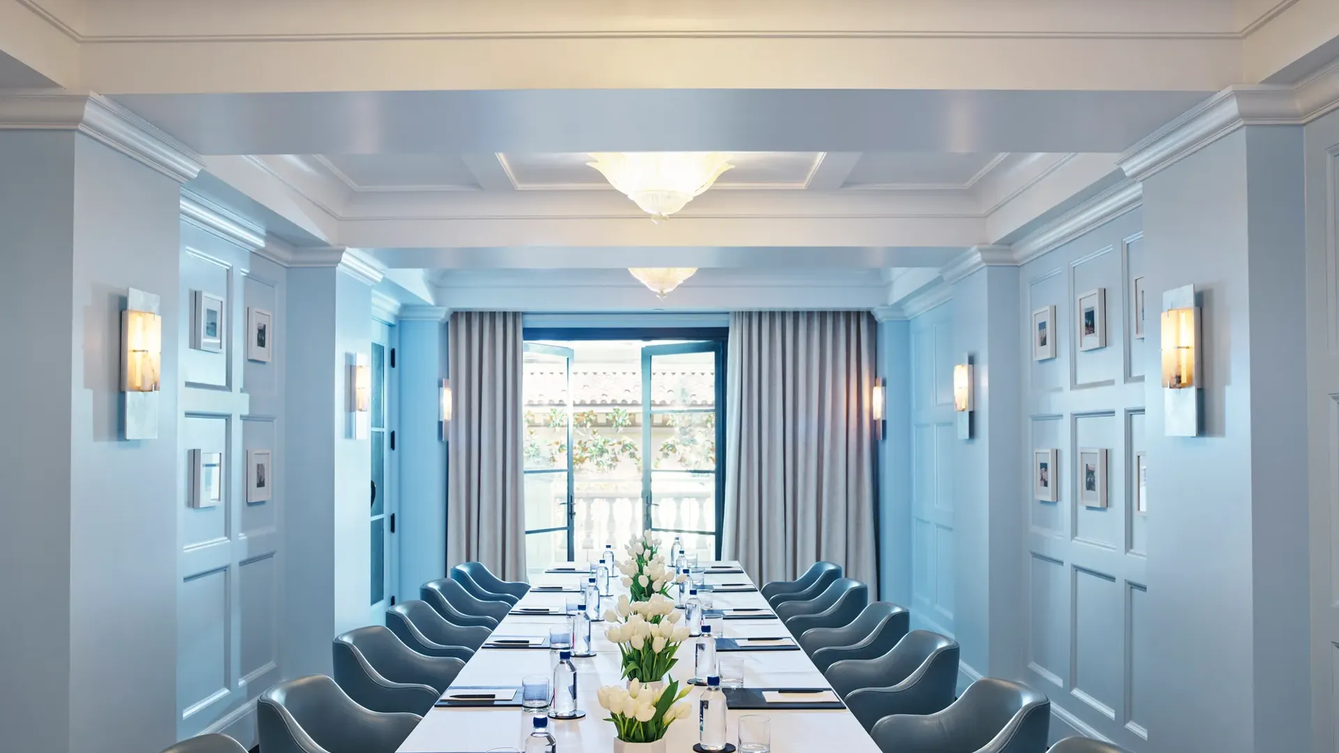 Canon Room boardroom setup with long table, blue paneling, and chandeliers.