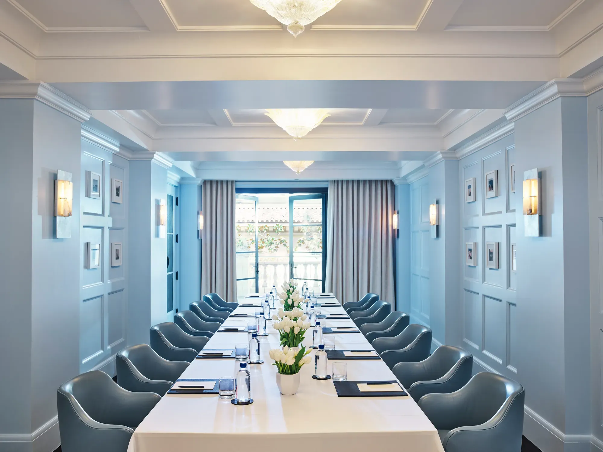 Canon Room boardroom setup with long table, blue paneling, and chandeliers.
