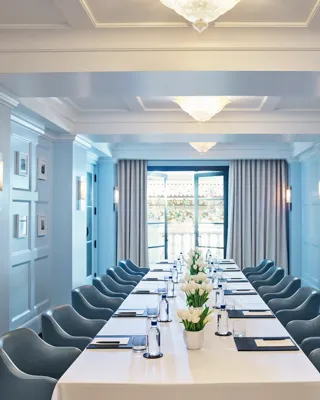 Canon Room boardroom setup with long table, blue paneling, and chandeliers.