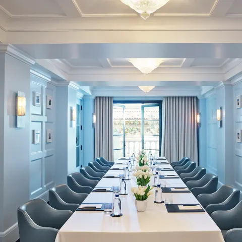 Canon Room boardroom setup with long table, blue paneling, and chandeliers.