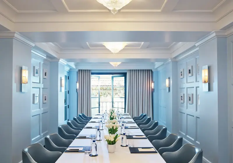 Canon Room boardroom setup with long table, blue paneling, and chandeliers.