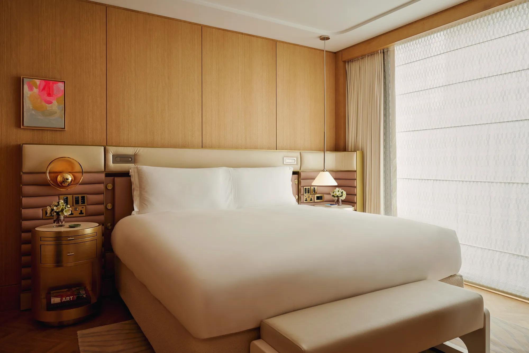 A tidy bedroom with a neatly made bed, soft lighting, and simple furniture.